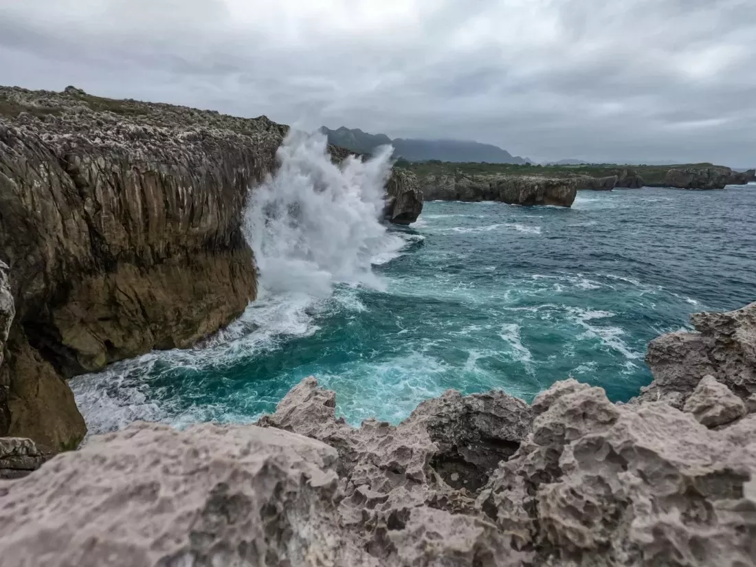 Welle bricht an einer felsigen Klippe am Meer in Asturien